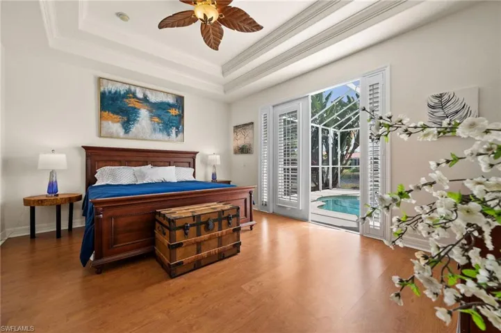 Master Bedroom with a tray ceiling, access to outside, and hardwood / wood-style flooring