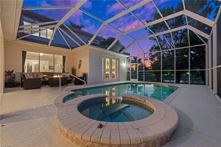 Pool at dusk with an in ground hot tub and a great size pool.
