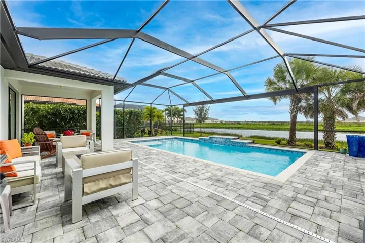 View of swimming pool featuring glass enclosure and a patio area