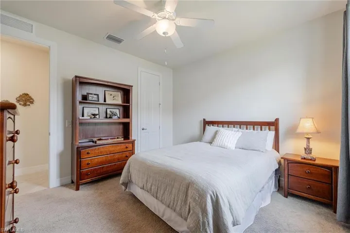 Carpeted bedroom featuring ceiling fan