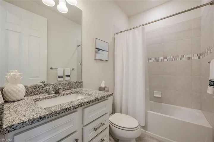 Full bathroom with shower / bath combination with curtain, toilet, and vanity
