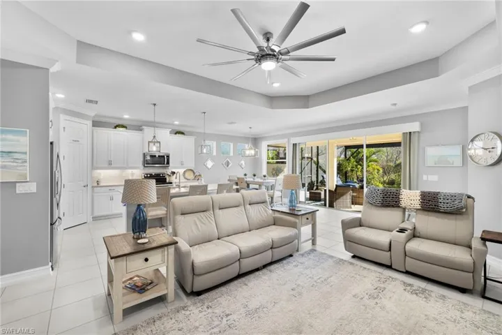 Tiled living room featuring ceiling fan, crown molding, and sink