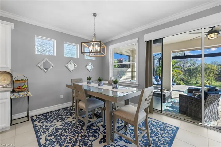 Dining area with light tile patterned floors and crown molding