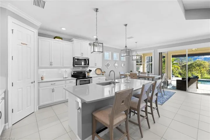 Kitchen featuring a kitchen island with sink, white cabinetry, sink, and appliances with stainless steel finishes