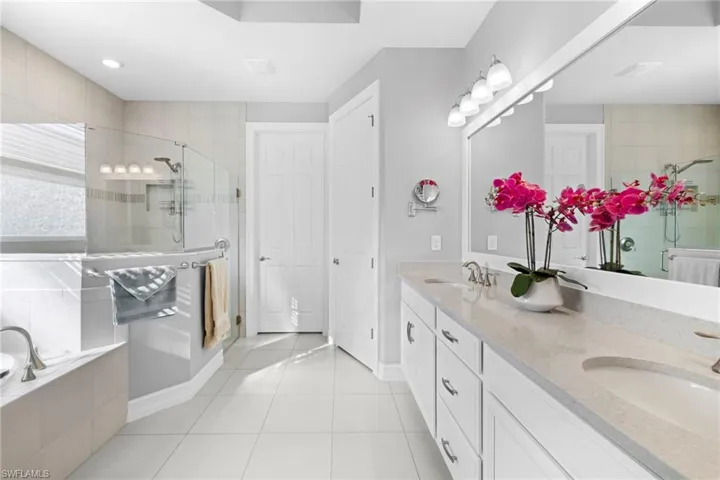 Bathroom featuring tile patterned floors, vanity, and separate shower and tub