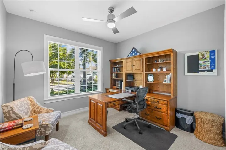 Carpeted office space featuring ceiling fan