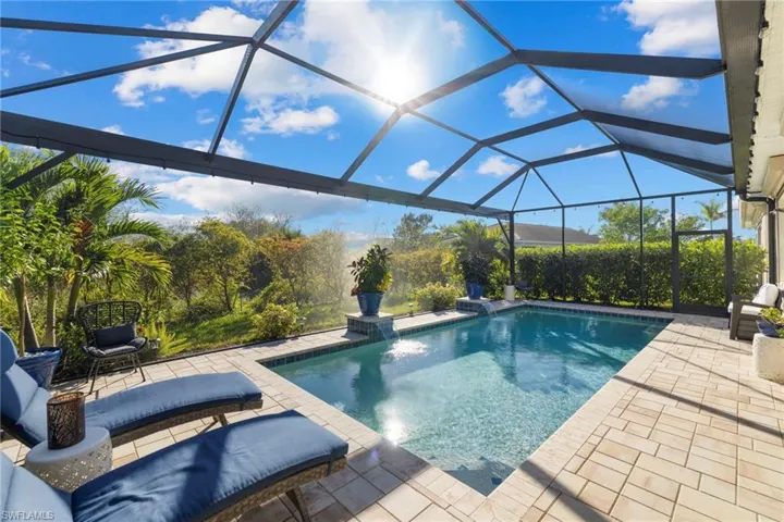 View of swimming pool featuring a lanai, pool water feature, and a patio