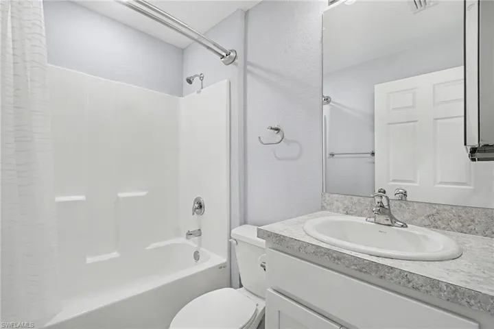 Bathroom with shower / bath combination with curtain and vanity