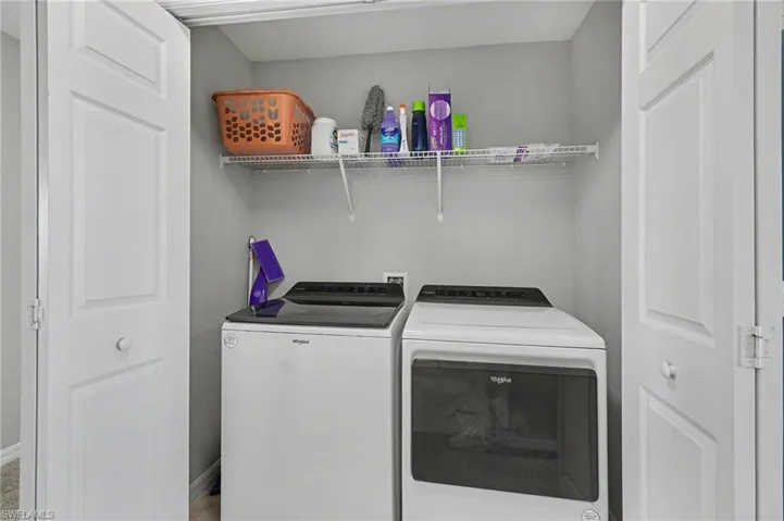 Laundry area with washing machine and clothes dryer and baseboards