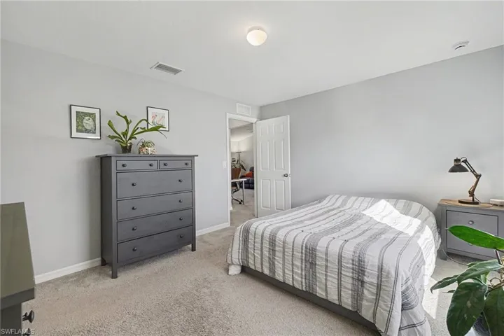 Bedroom featuring light colored carpet and baseboards