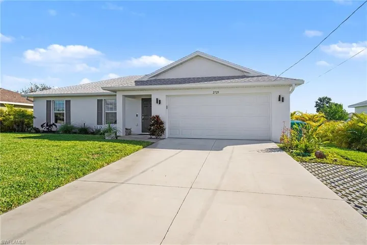 Ranch-style home with stucco siding, concrete driveway, a front lawn, and an attached garage