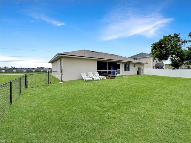 Rear view of property featuring a fenced backyard and stucco siding