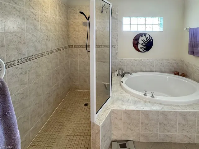 Bathroom featuring a garden tub and a shower stall