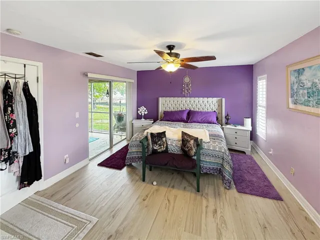 Bedroom with access to outside, wood finished floors, ceiling fan, and a closet