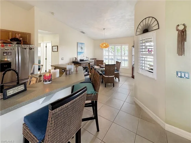 Dining space featuring vaulted ceiling and light tile patterned flooring