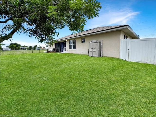 Rear view of property with stucco siding and a sunroom
