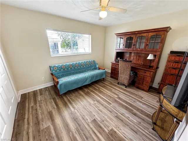 Office with light wood-type flooring and ceiling fan