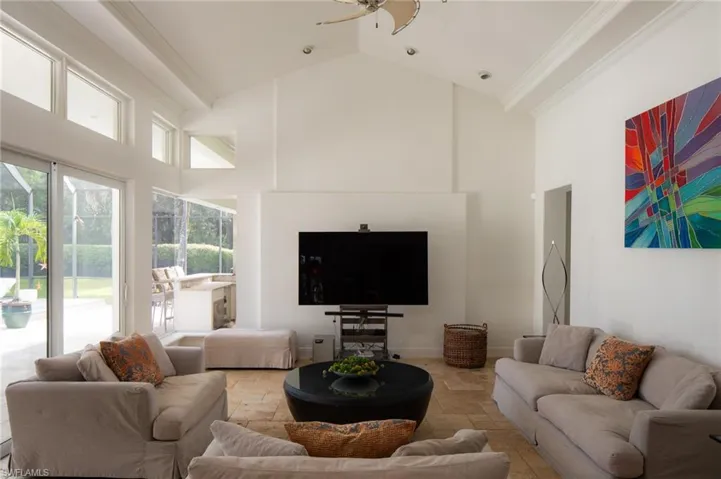 Living room featuring ornamental molding and high vaulted ceiling