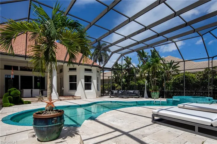 View of pool featuring glass enclosure and a patio area