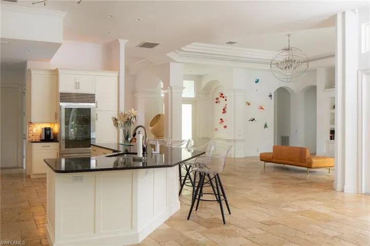 Kitchen featuring sink, a kitchen bar, oven, a chandelier, and crown molding