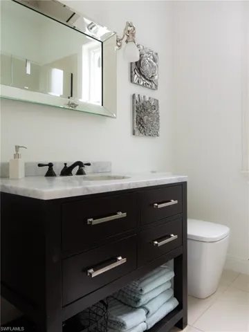 Bathroom featuring toilet, vanity, and tile patterned flooring