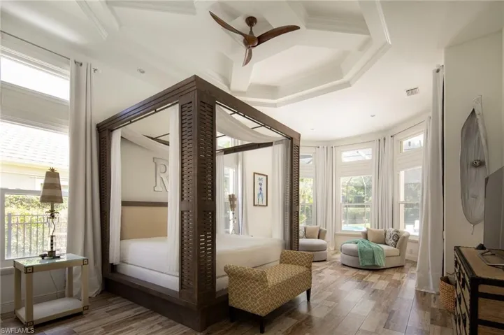 Bedroom with hardwood / wood-style floors, ceiling fan, crown molding, and coffered ceiling