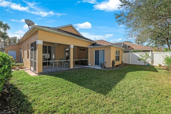 Rear view of property with a sunroom and a yard