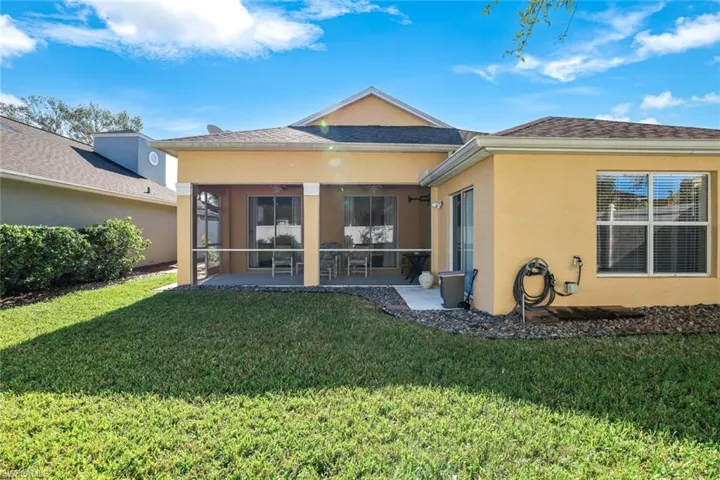 Back of house with a sunroom, a yard, and a patio