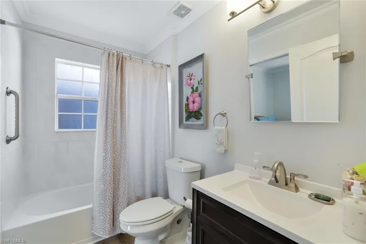 Full bathroom featuring vanity, shower / bath combo, toilet, and crown molding