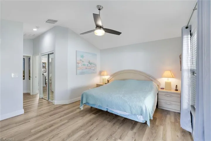 Bedroom with ceiling fan, light hardwood / wood-style flooring, and lofted ceiling