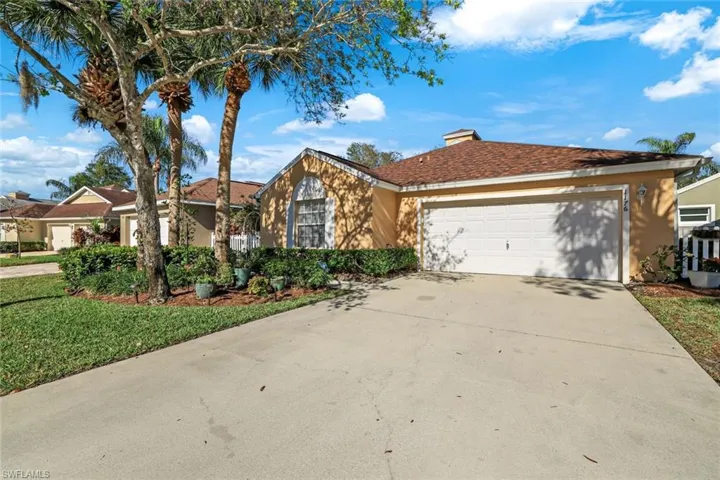View of front of home with a garage and a front lawn
