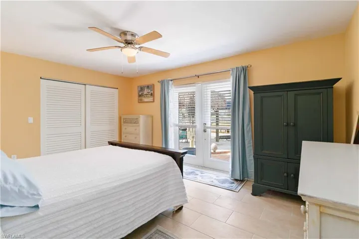 Bedroom featuring light tile patterned floors, a ceiling fan, access to outside, french doors, and a closet