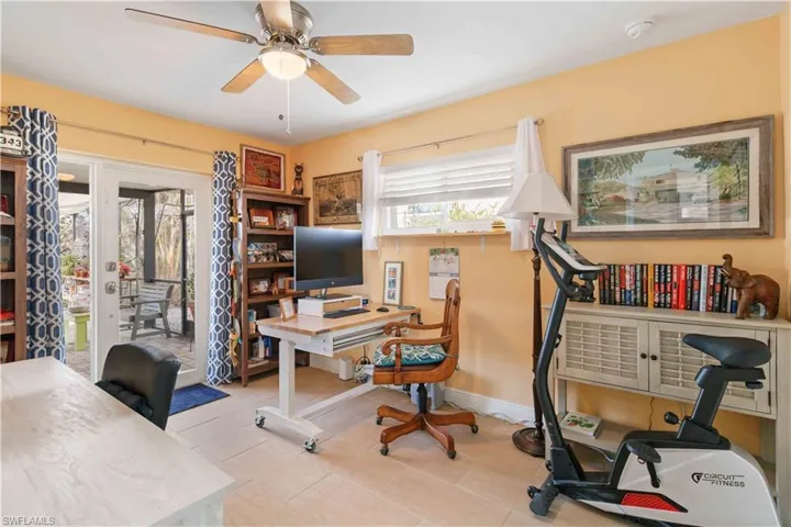 Tiled home office with ceiling fan and baseboards