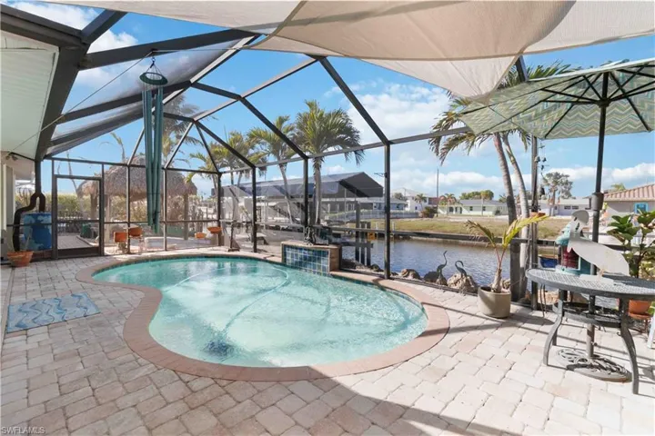 Pool with a water view, a patio area, and a lanai
