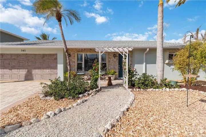 Ranch-style home featuring a garage, a shingled roof, driveway, a pergola, and stucco siding