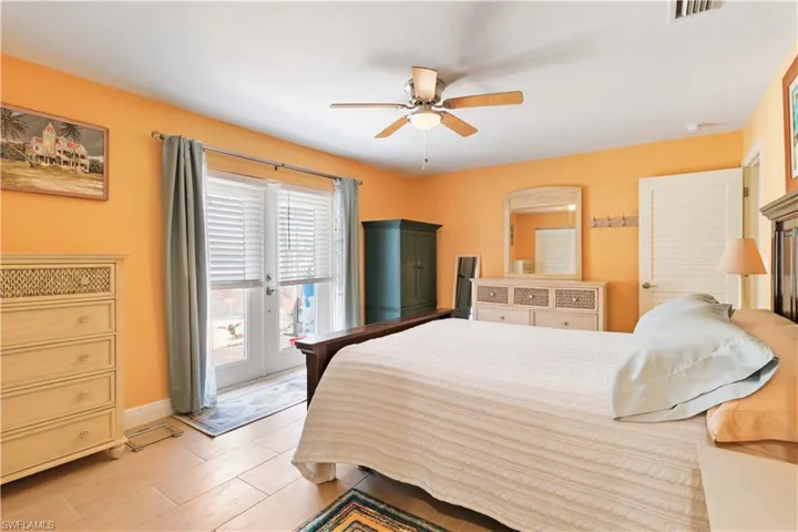 Bedroom with baseboards, access to outside, visible vents, and a ceiling fan