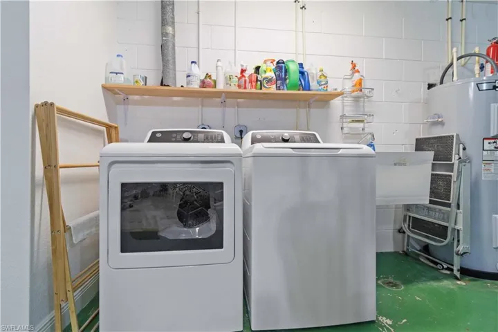 Laundry area with laundry area, water heater, and separate washer and dryer