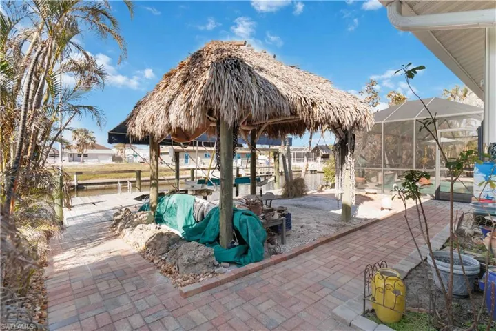 View of patio with glass enclosure and a boat dock
