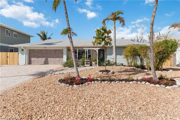 Single story home featuring a garage, fence, decorative driveway, and stucco siding