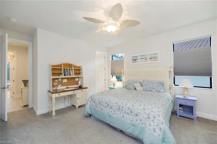 Bedroom with light colored carpet and ceiling fan