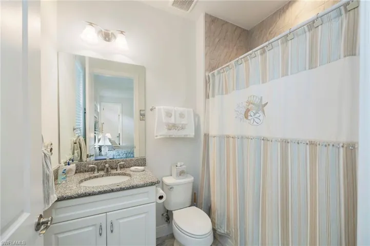 Bathroom featuring a shower with curtain, vanity, and ensuite bath