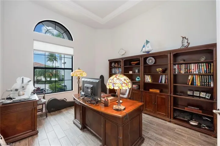 Office area featuring wood tiled floors, ornamental molding, and a tray ceiling