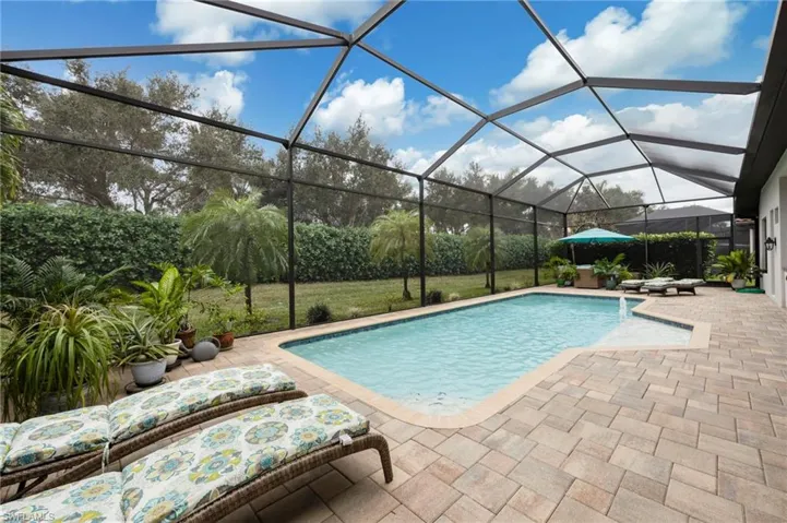 Swimming pool with a lanai, a sunroom, and a patio area