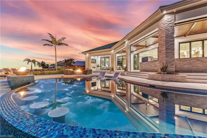 Pool at dusk featuring an outdoor fire pit
