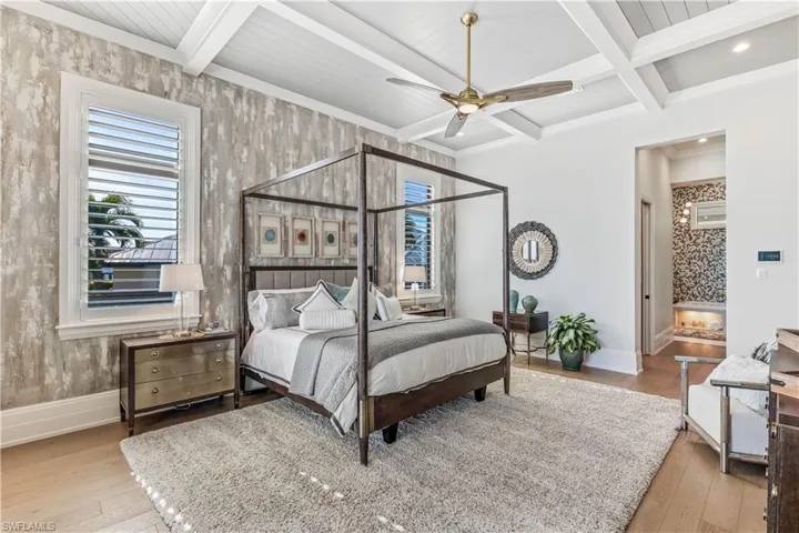 Bedroom with beam ceiling, ceiling fan, light hardwood / wood-style floors, and coffered ceiling