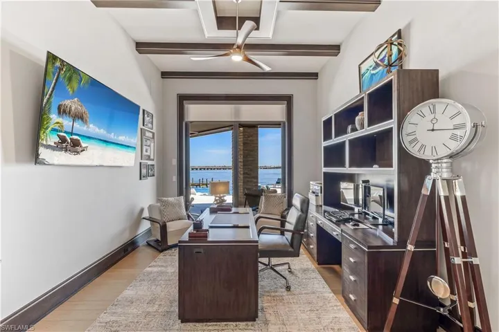 Office space with beam ceiling, ceiling fan, and light hardwood / wood-style flooring