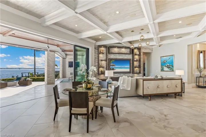 Dining area featuring beam ceiling, crown molding, a water view, and coffered ceiling