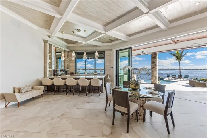 Dining space featuring beamed ceiling, a water view, ceiling fan, and coffered ceiling