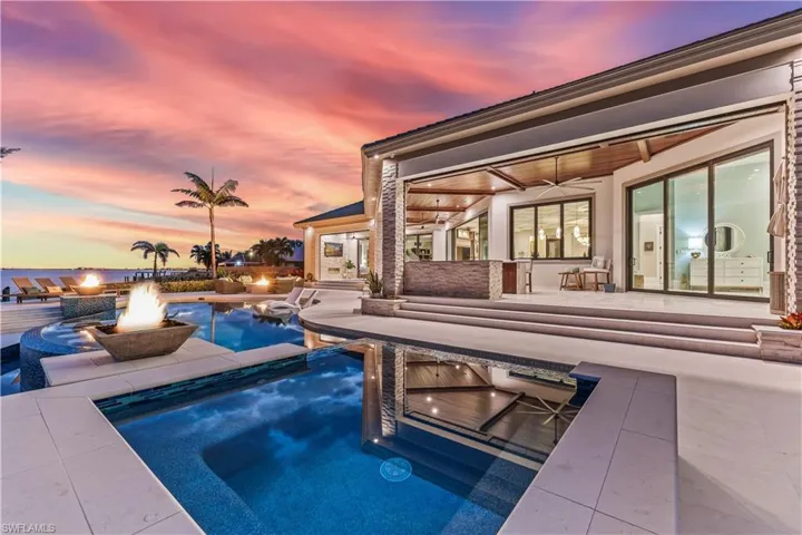 Pool at dusk with a fire pit and ceiling fan