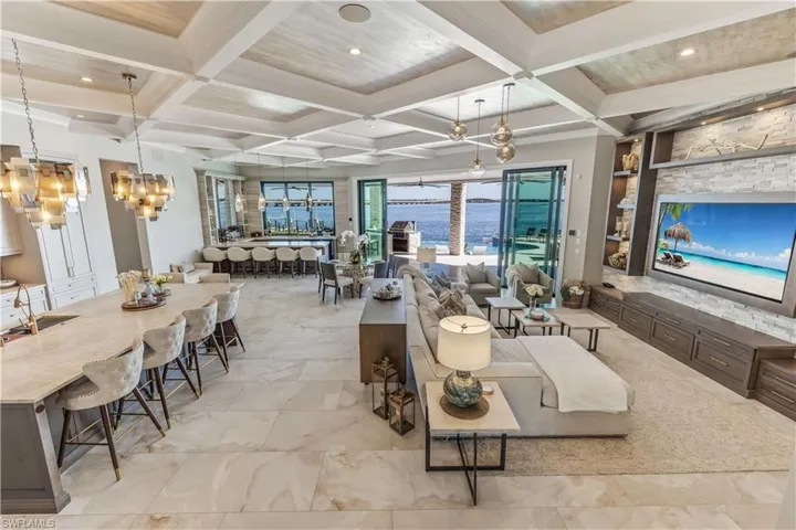 Living room featuring beamed ceiling, a notable chandelier, and coffered ceiling